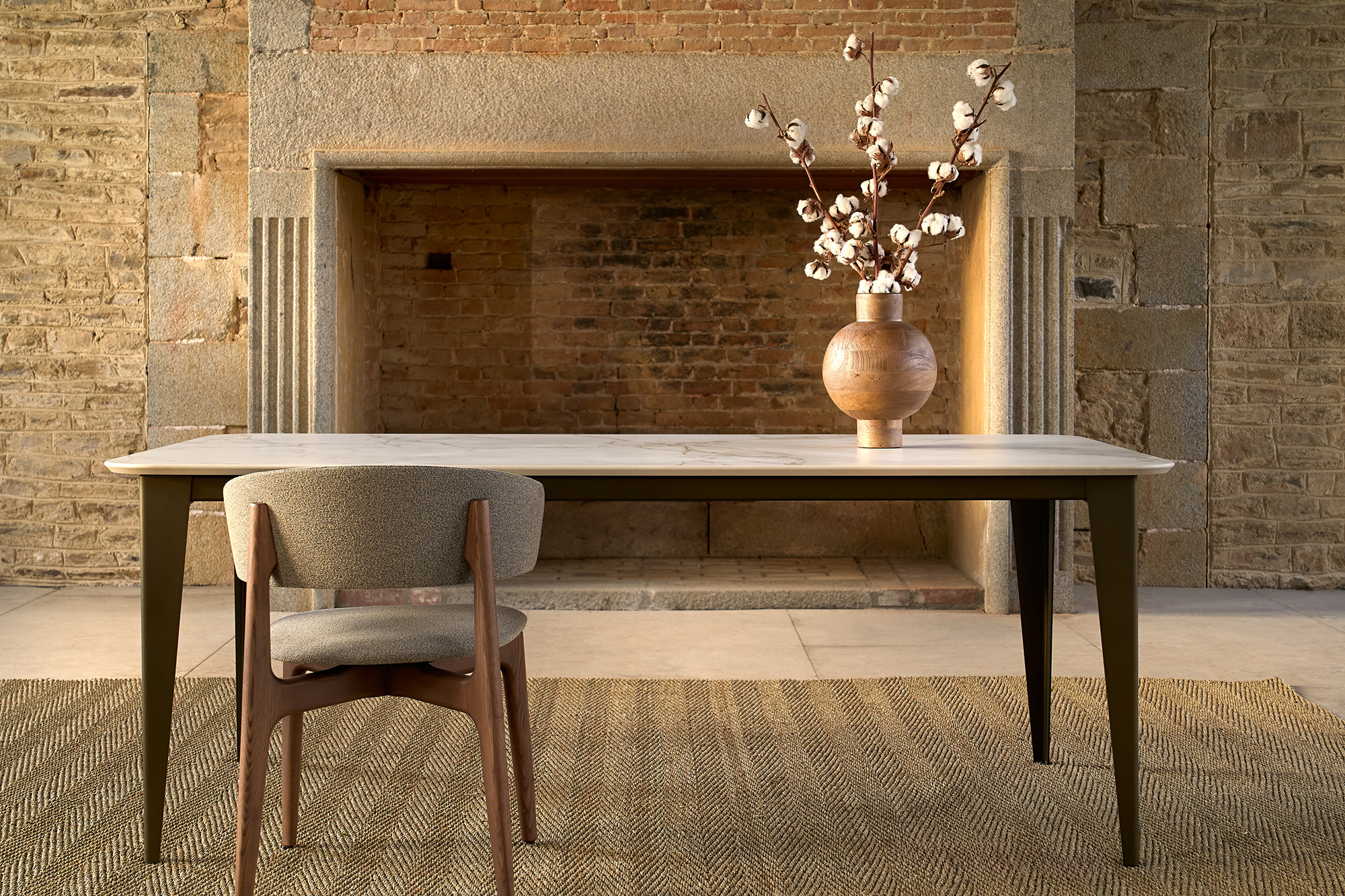 Table artisanale céramique Dekton modèle Comtesse ARTMETA 4K vue devant cheminée Table céramique Dekton modèle Comtesse / Dimensions : 200x100xH75 cm / Plateau : Entzo Pieds : Bronze / Fabrication ARTMETA